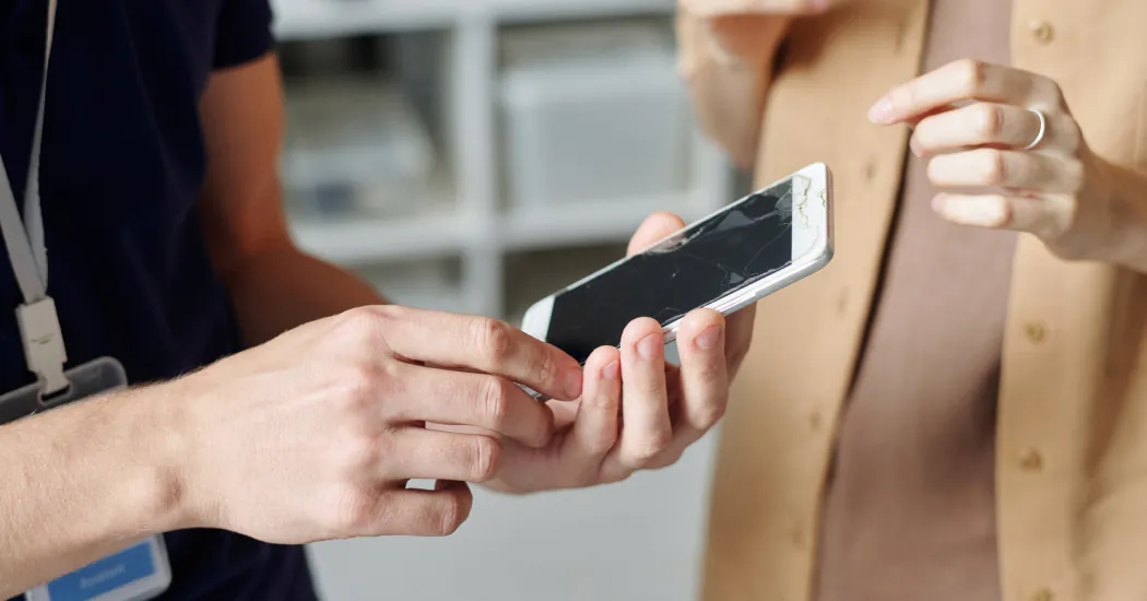 A damaged smartphone is examined prior to repair