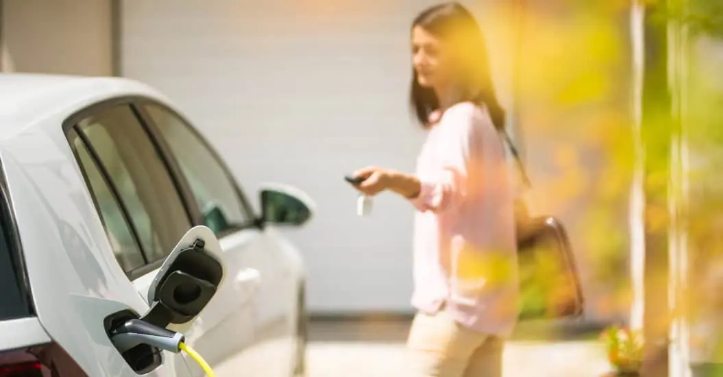 Woman locking her car with key remote