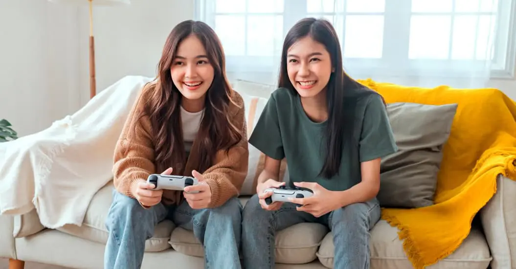 Two young adult females gaming at home