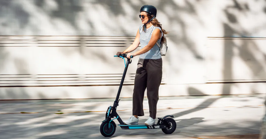A young woman riding an e-scooter